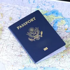Granatowy paszport USA leżący na mapie Stanów Zjednoczonych.